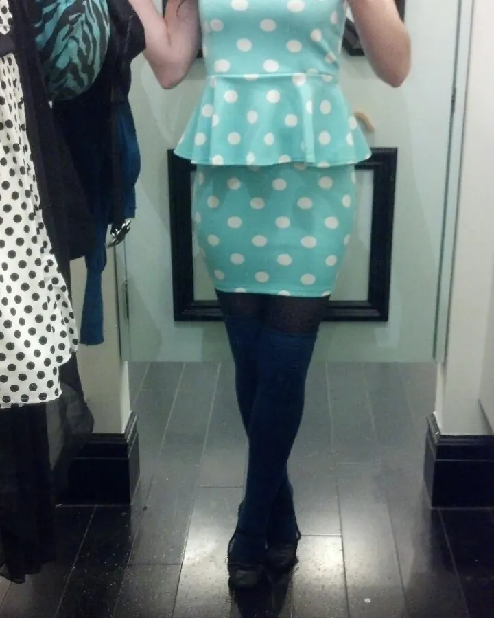 Femme brune en robe à pois turquoise, selfie dans un miroir